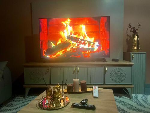 a living room with a fire on the tv at فيلا عبد الله غيات in Had Abdallah Rhiat