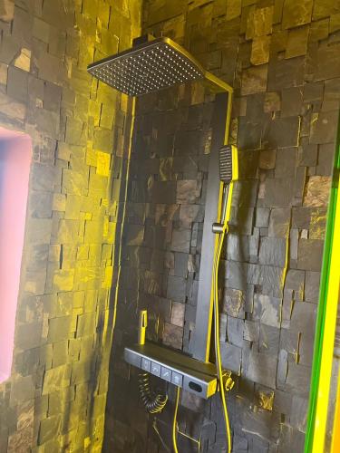 a shower in a bathroom with a stone wall at فيلا عبد الله غيات in Had Abdallah Rhiat