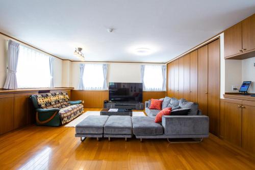 a living room with a couch and a table at No1 Private Hotel&Villa Aomoril 186平米貸切 最大12名 in Aomori