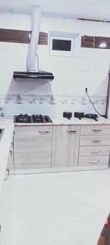 a white kitchen with a stove top oven at Cléopâtre la chrétienne in Tefeschoun