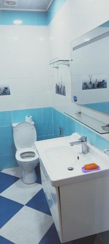 a blue and white bathroom with a toilet and a sink at Cléopâtre la chrétienne in Tefeschoun