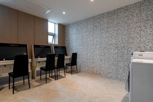 a waiting room with black chairs and a wall at 충주 어반브라운호텔 in Chungju