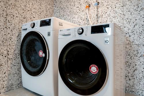 a white washing machine sitting in a bathroom at 충주 어반브라운호텔 in Chungju