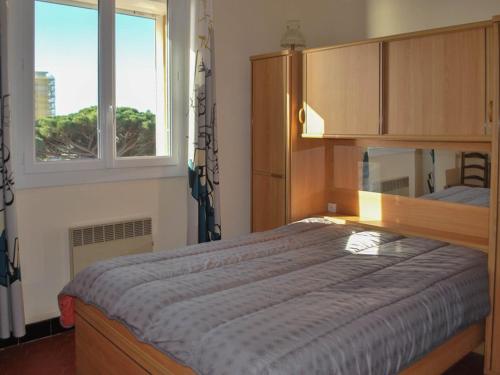 une chambre avec un grand lit et deux fenêtres dans l'établissement Le Lavandou: T2 4 couchages proche plage avec WIFI - FR-1-803-39, au Lavandou