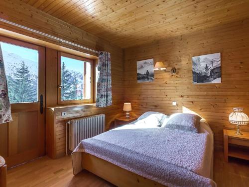 una camera da letto con un letto in una stanza di legno di Chalet familial 10 pièces à Meribel, proche des pistes, avec cheminée et terrasse, 12 personnes - FR-1-180-625 a Les Allues