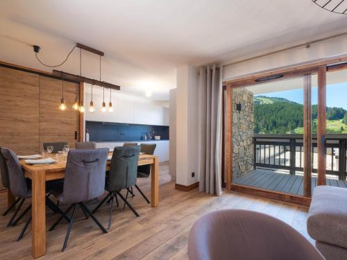 une cuisine et une salle à manger avec une table et des chaises dans l'établissement Appartement Familial au Centre de Courchevel Moriond avec Parking et Balcon - FR-1-563-156, à Courchevel