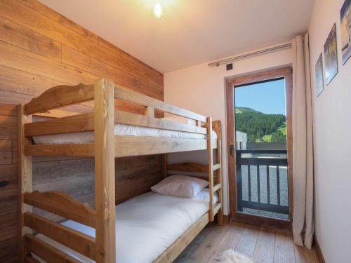 une chambre avec deux lits superposés et un balcon dans l'établissement Appartement Familial au Centre de Courchevel Moriond avec Parking et Balcon - FR-1-563-156, à Courchevel
