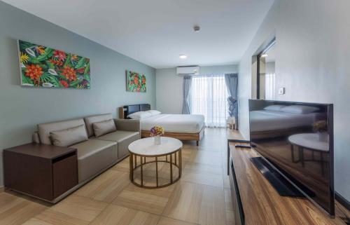 una sala de estar con un sofá y una cama en Chiva Bangkok Hotel - SHA Plus, en Bangkok
