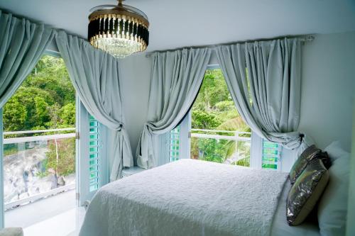a bedroom with a bed and a large window at El Yunque Waterfalls Romantic Stay at Casa Parcha in Naguabo