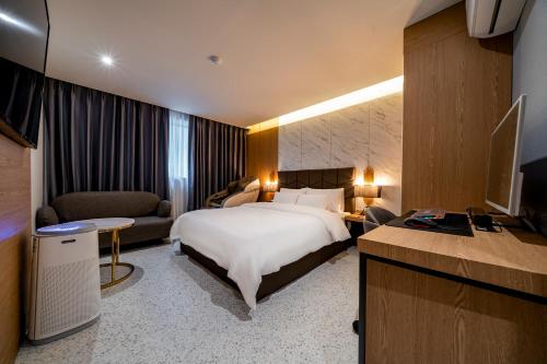 a hotel room with a bed and a couch at 충주 어반브라운호텔 in Chungju