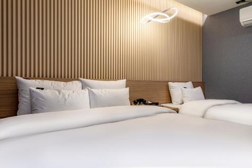 two beds sitting next to each other in a bedroom at 충주 어반브라운호텔 in Chungju