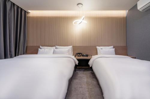 two beds sitting next to each other in a room at 충주 어반브라운호텔 in Chungju