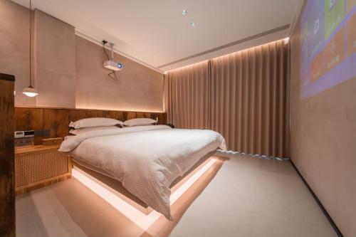 a bedroom with a bed with a light on the wall at 云漫山居民宿 in Xinglong