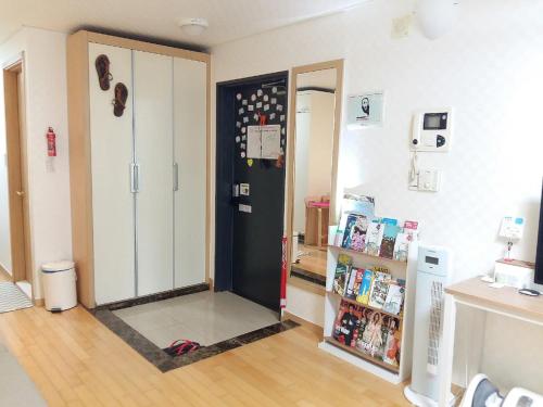 a room with a black refrigerator and a book shelf at Hongik Univ Hongdae Stay in Seoul