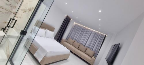 a living room with a couch and a glass wall at Platinum INN The City in Vlorë