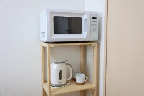 a microwave and a coffee maker on a shelf at ハイクレスト中野201 in Tokyo