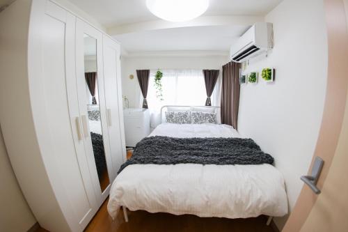 a bedroom with a white bed and a window at ハイクレスト中野201 in Tokyo