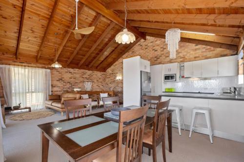 a kitchen and living room with a table and chairs at Sunset House on the Hill in Kingscliff