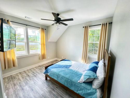 a bedroom with a bed and a ceiling fan at Seabrook Coastal Cottage - Beaufort Parris Island in Seabrook