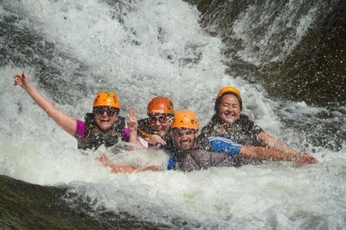a group of people rafting in a waterfall at El Yunque Waterfalls Romantic Stay at Casa Parcha in Naguabo
