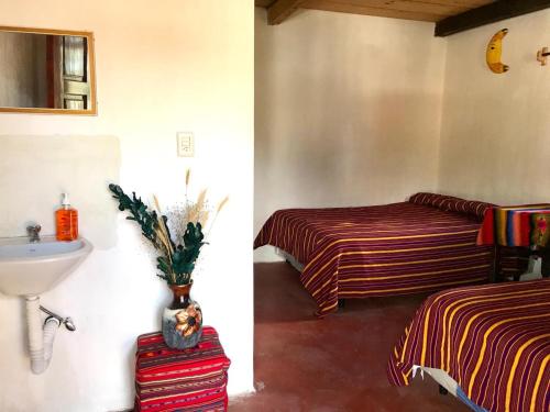 a bathroom with two beds and a sink at Casa Diego Ignacio in Chichicastenango