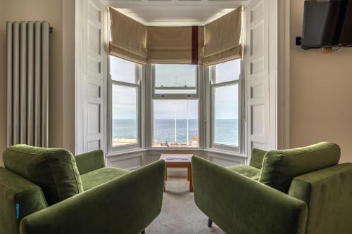 un soggiorno con due sedie e una grande finestra di Gwesty Cymru ad Aberystwyth