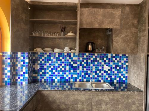 a kitchen with a sink and blue tiles on the counter at AT Hotel & Cafe in Phu Quoc