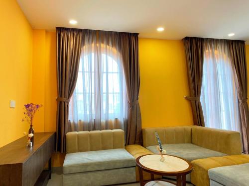 a living room with a couch and a large window at AT Hotel & Cafe in Phu Quoc