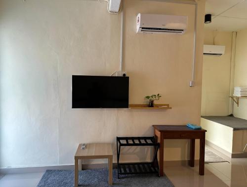 a living room with a flat screen tv on a wall at Nibong Tebal Studio Home Stay in Nibung Tebal