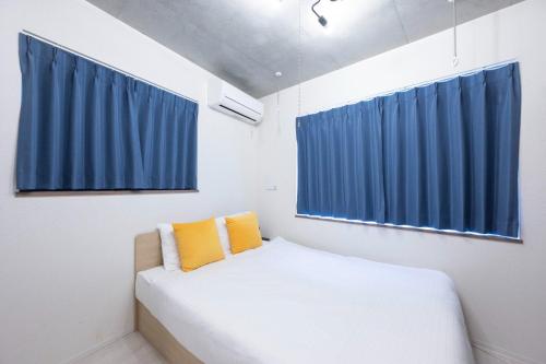 a small bedroom with blue curtains and a bed at Ferio Kamata II in Tokyo