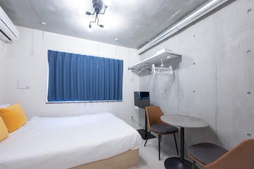 a room with a bed and a table and chairs at Ferio Kamata II in Tokyo