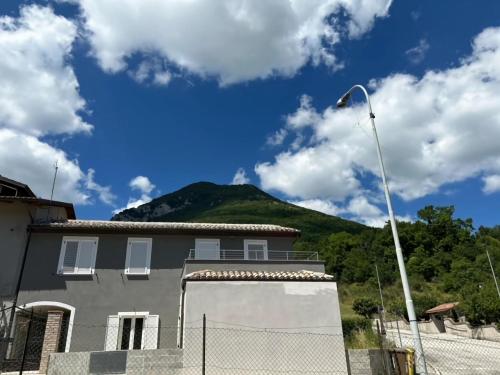 a building with a mountain in the background at Apartment in Esanatoglia near Apennines Trails in Esanatoglia