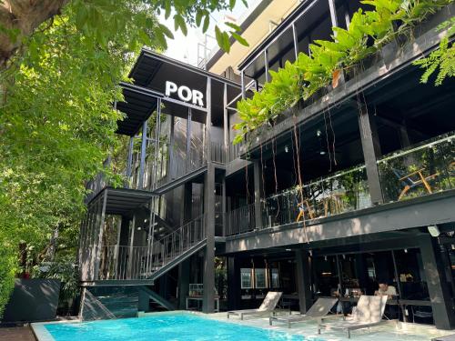 a building with a pool in front of it at POR Santitham in Chiang Mai