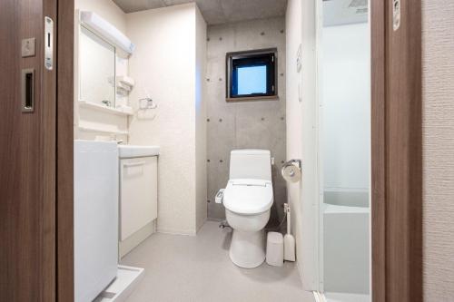 a white bathroom with a toilet and a sink at Ferio Kamata II in Tokyo