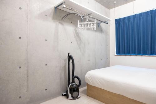 a small bedroom with a bed and a hanger at Ferio Kamata II in Tokyo