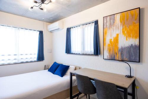 a bedroom with a bed and a table and chairs at Ferio Kamata II in Tokyo