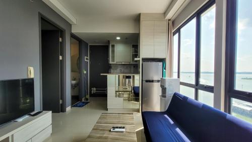 a kitchen with a blue couch in a room at Palam Mansion at Apartment One Residence in Batam Center