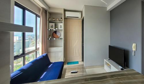 a living room with a blue couch and a tv at Palam Mansion at Apartment One Residence in Batam Center