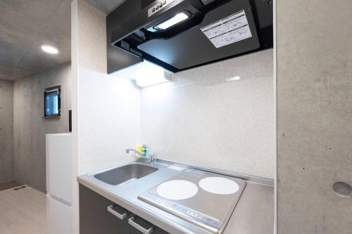 a small kitchen with a sink and a stove at Ferio Kamata II in Tokyo
