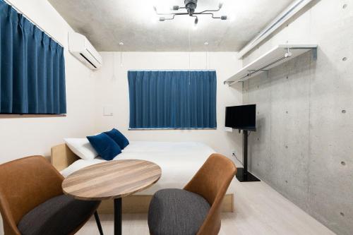 a bedroom with a bed and a table and chairs at Ferio Kamata II in Tokyo