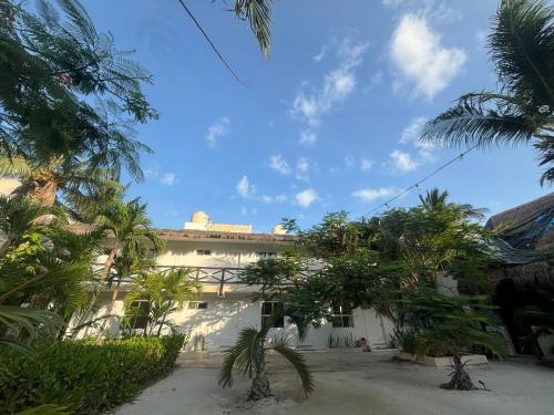 a building with palm trees in front of it at La Diosa Kali Beach Front Hotel in Holbox Island