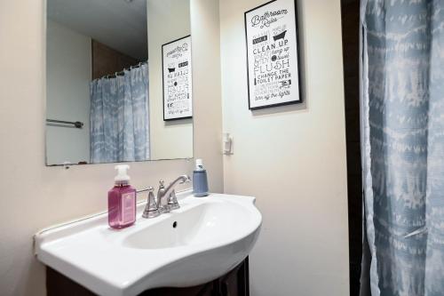 a bathroom with a white sink and a mirror at Cozy Home Close to Inner Harbor in Baltimore