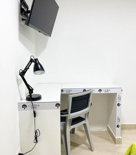 a desk with a lamp and a chair at Ceiba Rooms Hotel in Pereira