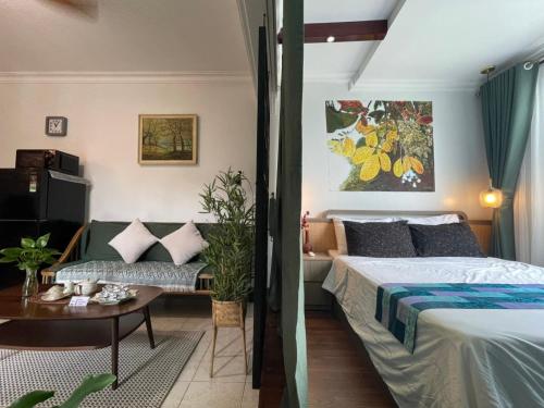 a bedroom with a bed and a couch and a table at Amazing View, Natural View, 3' To Hoan Kiem Lake, Free Wifi, Netflix, 2 Beds, 1 Toilet-2 Showers in Hanoi