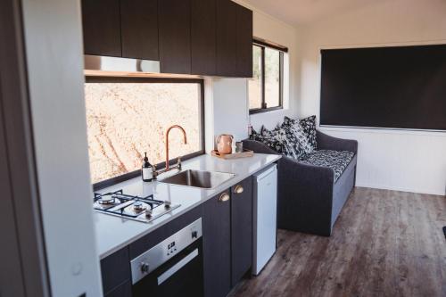 a kitchen with a sink and a couch in a room at High Valley Dawn Permaculture Farm in Yeppoon