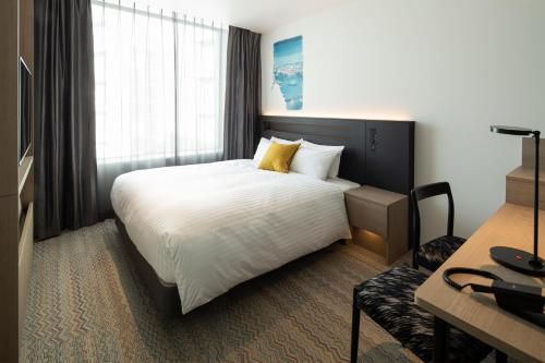 a hotel room with a bed and a desk at Hotel Intergate Osaka Umeda in Osaka