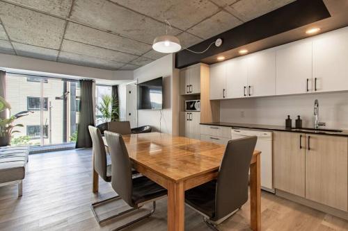 a kitchen and dining room with a wooden table and chairs at City Center, 2 bathroom, AC, Parking, Pool in Quebec City