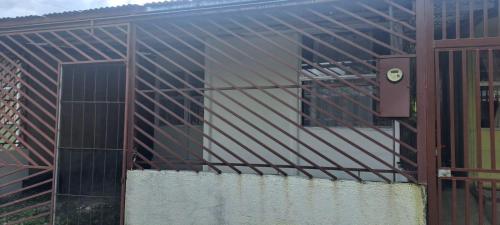 un edificio con techo de metal con una puerta en Casita Manu, en Rio Celeste