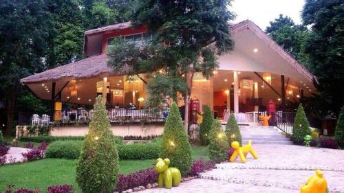 een huis met een tuin met teddyberen in de tuin bij Aurora Resort Kanchanaburi in Kanchanaburi