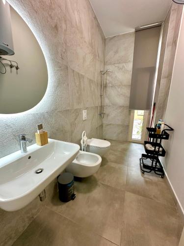 a bathroom with a white sink and a toilet at Queens Luxury Vila 111B in Vlorë